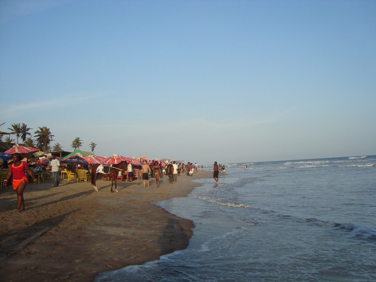 Umbrellas, horses and visitors along Labadi Beach, Accra